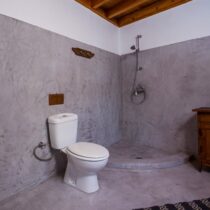 Badezimmer mit Toilette und Duschbereich